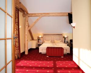 a hotel room with a bed and a red rug at Landhotel Böld Oberammergau in Oberammergau