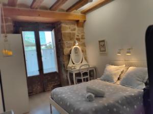 1 dormitorio con cama, mesa y espejo en Albergue Valderrobres, en Valderrobres