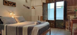 ein Schlafzimmer mit einem Bett und einem Fenster in der Unterkunft Albergue Valderrobres Auto check-in in Valderrobres