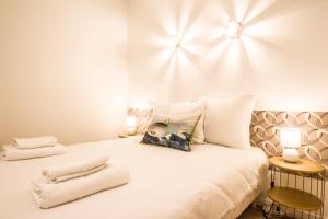 ein Schlafzimmer mit einem großen weißen Bett mit zwei Handtüchern darauf in der Unterkunft Le Petit Carmes - Joli studio de caractère in Toulouse