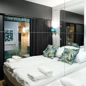 a bedroom with a large white bed with mirrored walls at Wave3 - Monte Cassino by OneApartments in Sopot