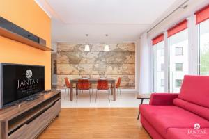コウォブジェクにあるJantar Apartamenty - Wyspa Solna City Centerのリビングルーム(赤いソファ、テレビ付)