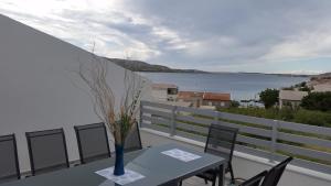 a table and chairs on a balcony with a view of the water at Big Blue - Xenija (Veliko Plavetnilo - Ksenija) in Metajna