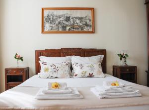 a white bed with white pillows and pillows on top of it at Casa Mindela Farmhouse in Vila do Conde