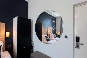 una camera da letto con specchio a parete di Quentin Amsterdam Hotel ad Amsterdam Altre 141 foto