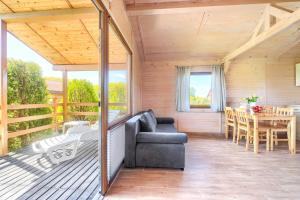 a screened in porch with a couch and a table at Duet Domki in Jarosławiec
