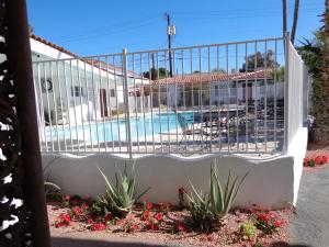a fence with a pool in the background at Coronado Motor Hotel in Yuma