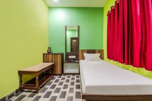 a room with two beds and a red curtain at Hotel Vivek in Patna