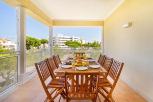 WHome | Vilamoura Family Apartment في كوارتيرا: غرفة طعام مع طاولة وكراسي ونافذة كبيرة