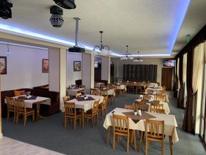 a dining room with tables and chairs in a restaurant at Hotel Velista in Voneshta Voda
