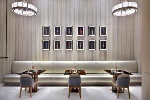 a room with a table and chairs with paintings on the wall at Address Sky View in Dubai