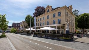 een gebouw met tafels en parasols in een stadsstraat bij Atlas Hotel in Valkenburg
