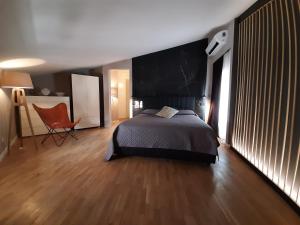 a bedroom with a bed and a chair in it at MoAA - Modern Art Apartment in Desenzano del Garda