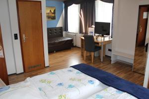 a bedroom with a bed and a desk with a computer at Hotel Restaurant Post Italia in Albstadt