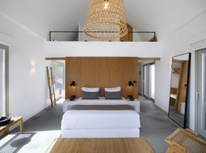 1 dormitorio con 2 camas y lámpara de araña en Melidonia Suites en Akrotiri