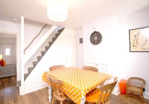 a dining room with a table and a staircase at Goodwin Sands in Deal