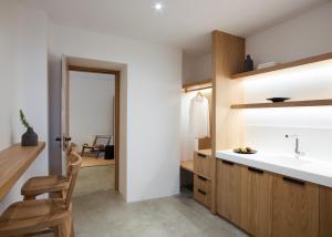 a small kitchen with a sink and a wooden cabinet at Melidonia Suites in Akrotiri