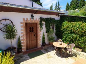 un patio con una mesa y una puerta de madera en CASA RURAL "LA CASITA" para 2 personas en Ronda