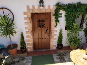 eine Holztür in einem Haus mit Topfpflanzen in der Unterkunft CASA RURAL "LA CASITA" para 2 personas in Ronda