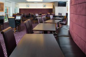 un ristorante con tavoli, sedie e un divano in pelle di Holiday Inn Express Bedford by IHG a Bedford