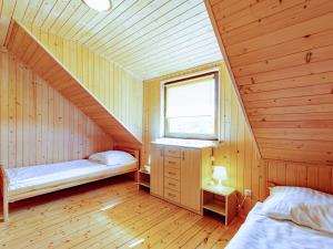 een zolderkamer met 2 bedden en een raam bij Domki Victoria in Ustka