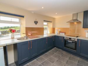 a kitchen with blue cabinets and a sink and a window at Crag View in Hexham