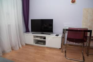 a living room with a television on a white cabinet at LOVELY ONE BEDROOM APARTMENT in Nové Zámky