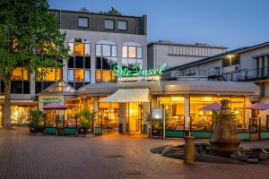 a building with a restaurant in front of it at Insel Hotel Bonn - Superior in Bonn