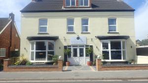 a white house with a white door on a street at The Victoria guest house in Mablethorpe