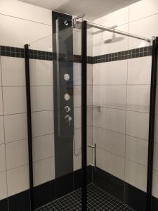 a shower in a bathroom with black and white tiles at Gästehaus Schmid in Sankt Johann im Saggautal
