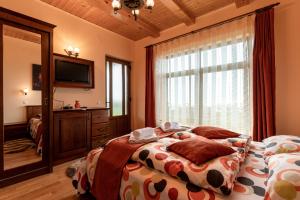 - une chambre avec un lit et une grande fenêtre dans l'établissement Pensiunea Turistică Vălari, à Păltiniş