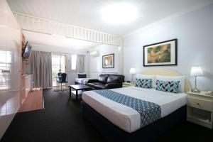 a hotel room with a bed and a desk at Toowong Central Motel Apartments in Brisbane