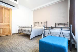 1 dormitorio con 2 camas y reposapiés azul en Toplik, en Sarajevo