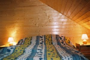 a bedroom with a bed in a wooden wall at chalet jennifer in Laveissière