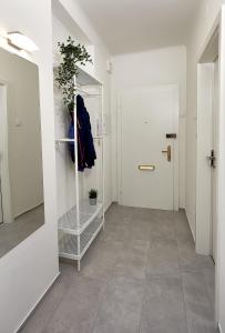 einen Flur mit einem Spiegel an der Wand und einer Tür in der Unterkunft Gemütliche Wohnung in zentraler Lage in Graz