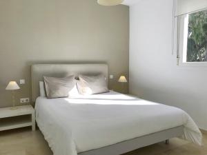 - un lit blanc dans une chambre avec fenêtre dans l'établissement Apartamentos Doña Carmen, à Malaga 43 autres photos