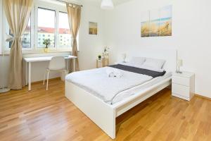 Habitación blanca con cama y escritorio en Gemütliche Wohnung in zentraler Lage en Graz