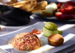a plate of food with a meat ball and a roll at Melidonia Suites in Akrotiri