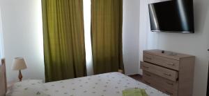 a bedroom with a bed and a dresser with a television at Splendid Aparthotel in Năvodari