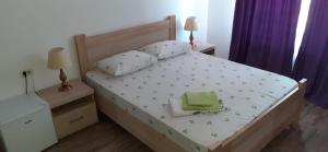 a bedroom with a bed with a green bag on it at Splendid Aparthotel in Năvodari