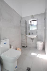 bagno bianco con servizi igienici e lavandino di Skoutari Bungalows Galateia room a Skoutari
