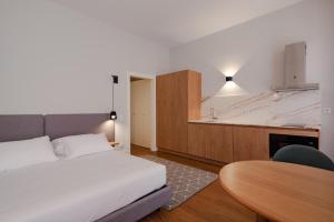 a bedroom with a bed and a table and a kitchen at Uma Formosa Apartments in Porto
