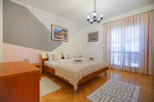 um quarto com uma cama e uma grande janela em Apartment Jardin em Zadar