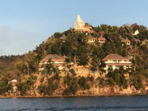 an island with houses on a hill in the water at Pearl Bay Villas in Concepcion