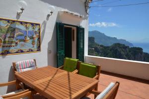 a wooden table and chairs on a balcony at Amalfi Hills in Amalfi