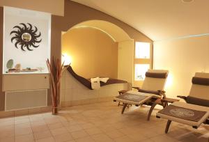 a bathroom with two chairs and a sink in a room at Autenrieder Gästehaus Schlossbräu in Autenried