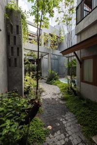 a courtyard with a walkway between two buildings at Hidden Garden Hostel in Chiang Mai