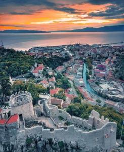 eine Luftansicht einer Stadt mit Sonnenuntergang in der Unterkunft Trsatika in Rijeka