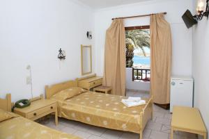 1 dormitorio con 2 camas y ventana con vistas en Asterias Hotel - Seafront en Parikia