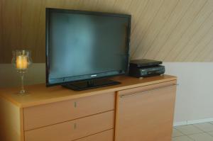 a flat screen tv sitting on top of a dresser at Ländlich ruhig 10 km vor Rostock in Dummerstorf